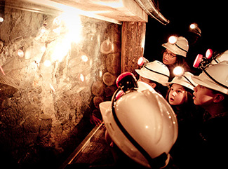 A group of children looking at gold in the quartz underground at Central Deborah Gold Mine